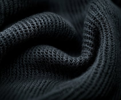 Luxurious dark boucle fabric showcasing intricate texture and depth in soft woven threads during a close-up view photo