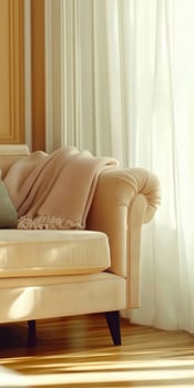 Soft fabric draped on a light-colored leather couch beside sheer white curtains in a cozy living room photo
