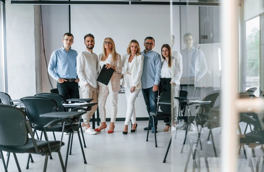 Standing and posing for a camera in the class.. Group of professional business people is in the office photo