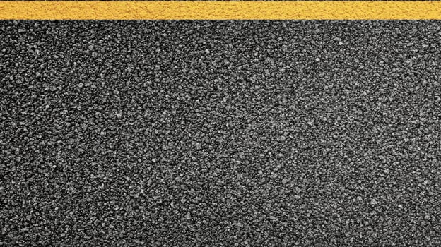 Close-up of textured asphalt road with yellow line dividing surface for transportation concept photo