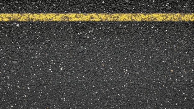 Close-up of asphalt road surface with yellow line for urban and transportation concept photo