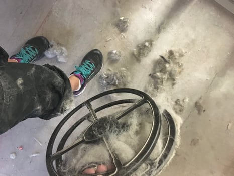 Holding a Filter Full of Pet Fur in a Grooming Salon, Overflowing Mess on Floor photo