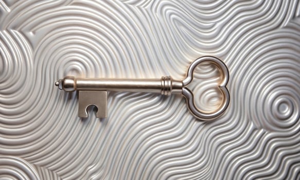 Metal decorative key on a relief surface with a wavy pattern photo