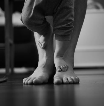 Newborn baby's feet on daddy's feet small and big feet photo