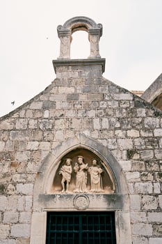 Facade of the church of St. Luke with statues of three saints above the entrance. Dubrovnik, Croatia photo