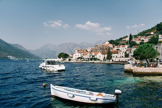 White fishing boat is moored at a pier near the shore of Perast. Montenegro photo