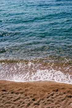 Sea waves roll on the sandy shore photo