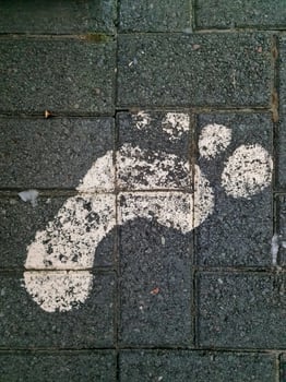 White footprint painted on a sidewalk in iceland guiding tourists photo