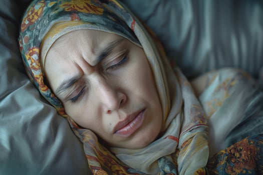 A Middle-Eastern woman with a headscarf resting her head on soft pillows, displaying a contemplative expression. photo