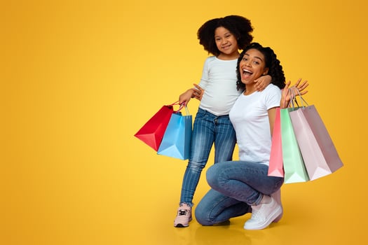 Shopping Fun. Overjoyed Afro Woman And Her Little Daughter Posing With Lots Colorful Shopper Bags Over Pink Background, Copy Space photo