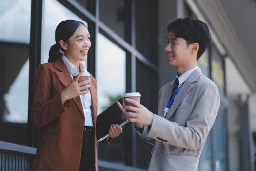 Asian business couple having coffee and talking outside photo