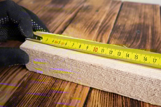 Closeup yellow measuring tape on wooden plank photo