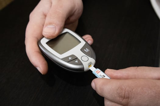 Close up man checking blood on sugar level. Home medical test. Concept of blood sugar level testing. photo