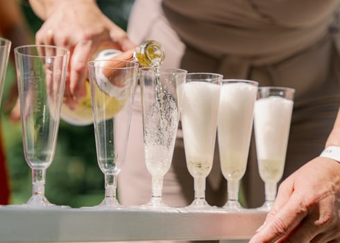 Girl pouring champagne into glasses photo