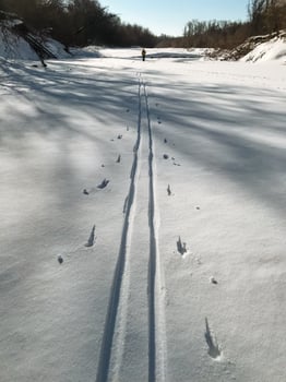 A person elegantly skis down a beautiful snowcovered road, surrounded by a stunning winter landscape that showcases the charm of freezing temperatures and glistening ice photo