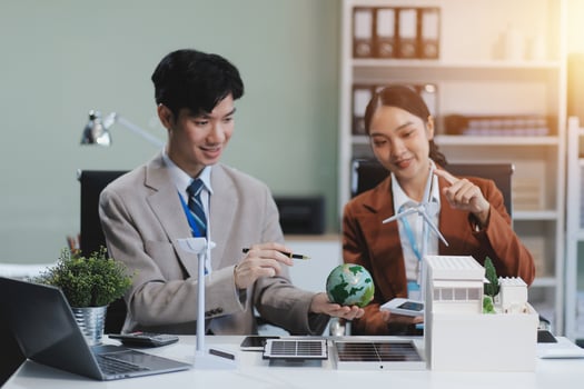 Asian business couple working together on laptop and tablet photo