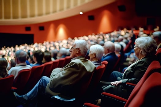 Elderly couple enjoying a show in a crowded theater photo