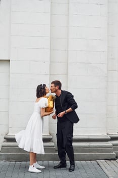 Playing with golden colored baloon. Beautiful bride with his fiance is celebrating wedding outdoors photo