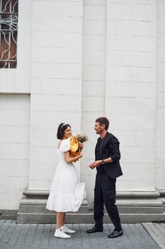 Playing with golden colored baloon. Beautiful bride with his fiance is celebrating wedding outdoors., photo