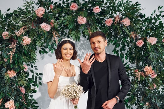 Wearing the rings. Beautiful bride with his fiance is on the wedding photo