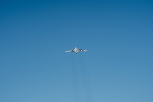 A plane is soaring gracefully and majestically through a vast and clear blue sky, taking full advantage of the beautiful and wonderful weather on this delightful sunny day photo