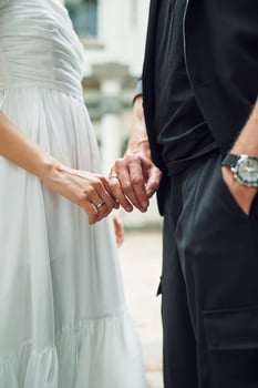 Close up view. Holding by the hands. Beautiful bride with his fiance is celebrating wedding outdoors. photo