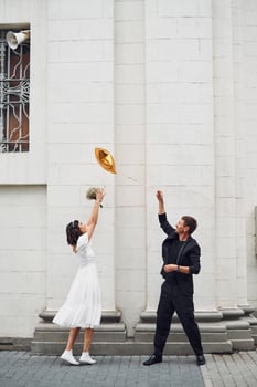 Playing with golden colored baloon. .Beautiful bride with his fiance is celebrating wedding outdoors photo