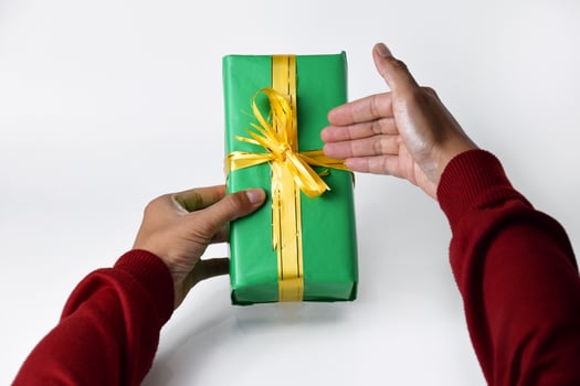 Hands Offering a Green Present Close-Up photo