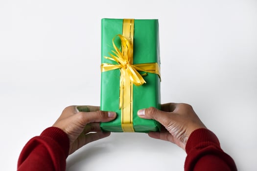 Close-Up of Hands Offering a Green Gift Box photo