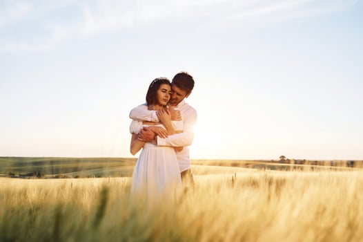 Against beautiful landscape. ,Couple just married. Together on the majestic agricultural field at sunny day photo