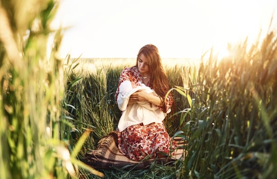 Conception of parenting. Gorgeous woman is on the agricultural field with her newborn baby photo