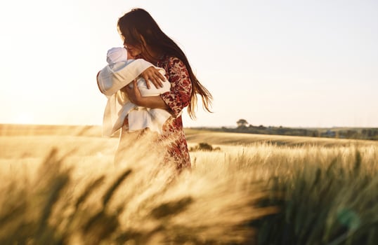 Conception of parenting. Gorgeous woman is on the agricultural field with her newborn baby., photo
