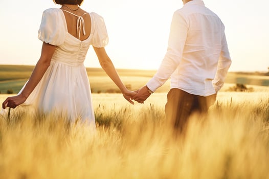 Rear view. Couple just married. Together on the majestic agricultural field at sunny day photo