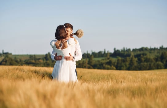 Couple just married. Together on the majestic agricultural field at sunny day photo
