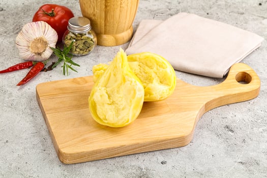 A wooden cutting board with a half peeled banana on it photo