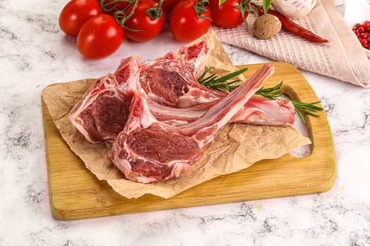 A cutting board with some raw meat and vegetables photo