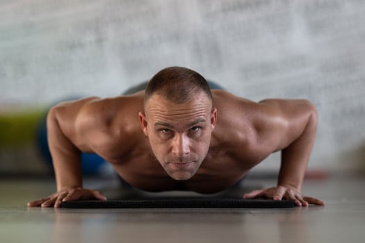 A muscular man performing push ups in the gym, showcasing strength, endurance, and dedication to his fitness routine. photo