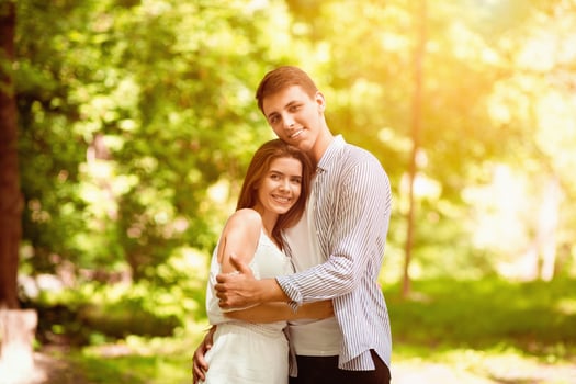 Romantic times together. Young couple in love embracing at sunny summer park photo