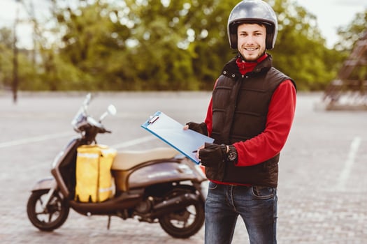Courier Job. Delivery Guy Offering Delivering Services Holding Folder And Pen Standing Near Scooter Outdoors photo