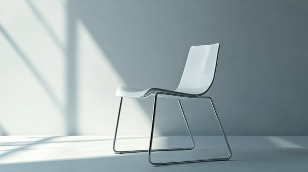 A minimalist white chair with a sleek metal frame in a softly lit room. photo
