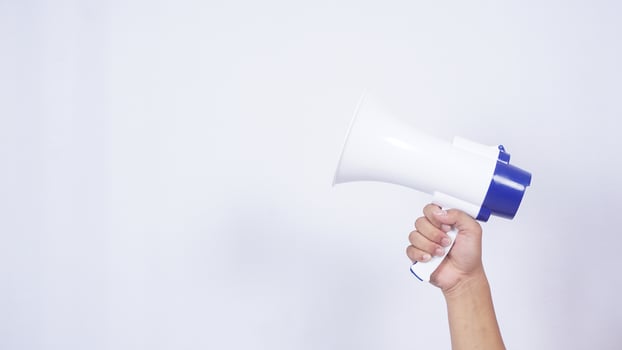 Close up of hand holding megaphone isolated on white background photo