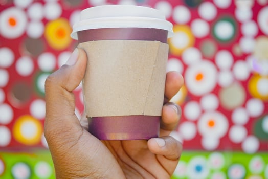 Colorful background with hand holding a coffee cup photo