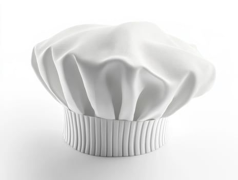 Chef hat displayed on a plain background indoors photo