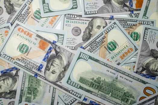 Stacks of hundred dollar bills spread out on a surface highlighting the details of the new currency design photo