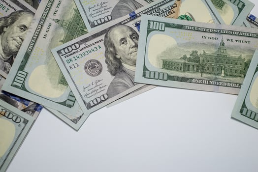 Stacks of hundred dollar bills arranged creatively on a flat surface for marketing photo