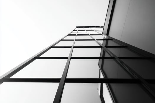 A low-angle view of a modern glass building, emphasizing its sleek architectural design. photo