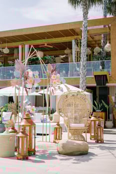 Wicker chair stands near a colorful wedding arch on the shore of a hotel pool photo