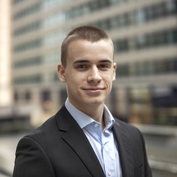 A young man in a suit and tie standing in front of a building photo