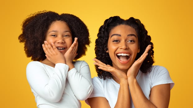 Overjoyed Black Millennial Mom And Her Adorable Little Daughter Touching Cheeks In Excitement, Emotionally Reacting To Something, Pink Background photo