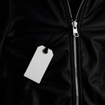A black jacket with a white tag hanging from the zipper photo